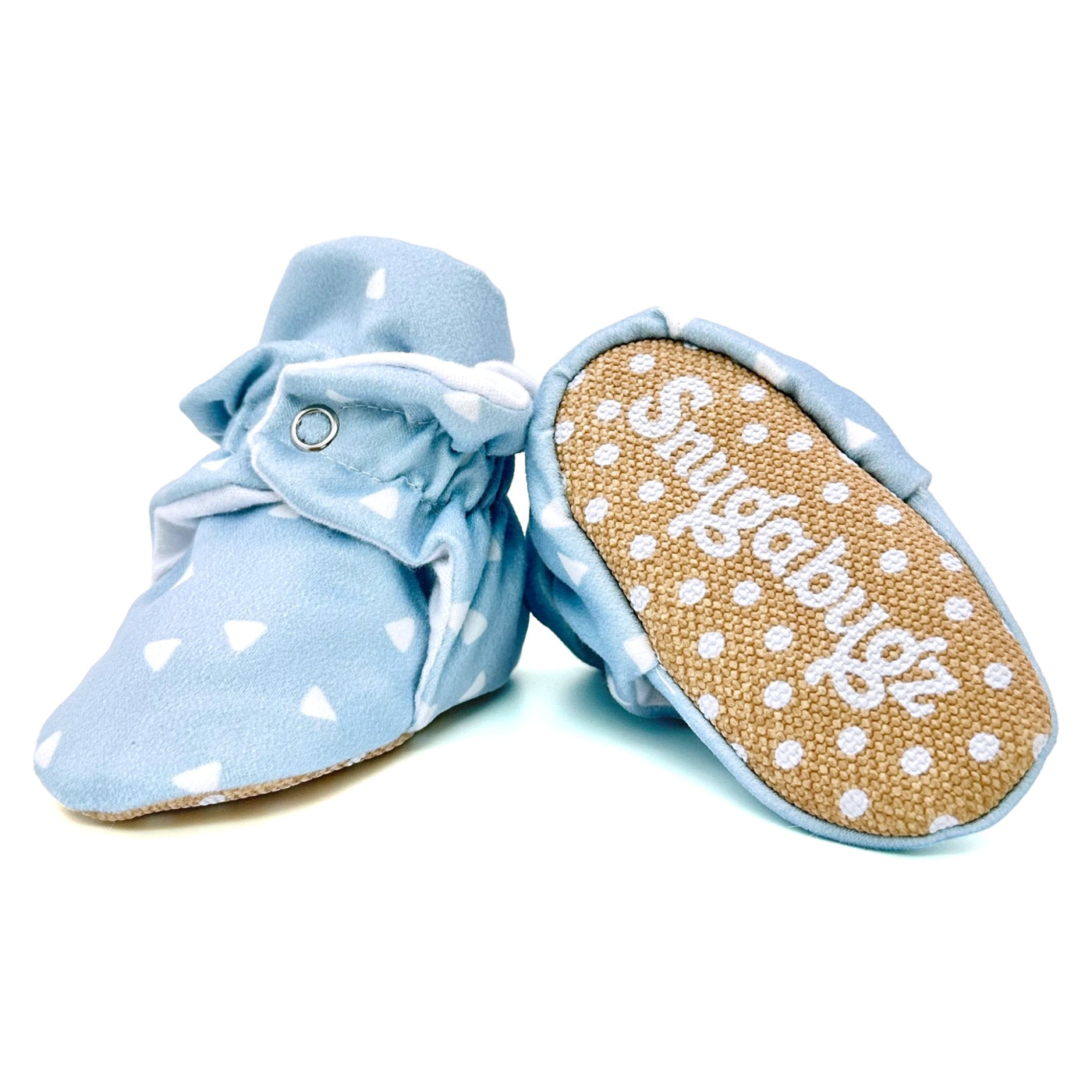 Stay-on baby booties featuring white triangles on a baby blue background print, with non-slip soles and adjustable three snap closure. Made from organic cotton.