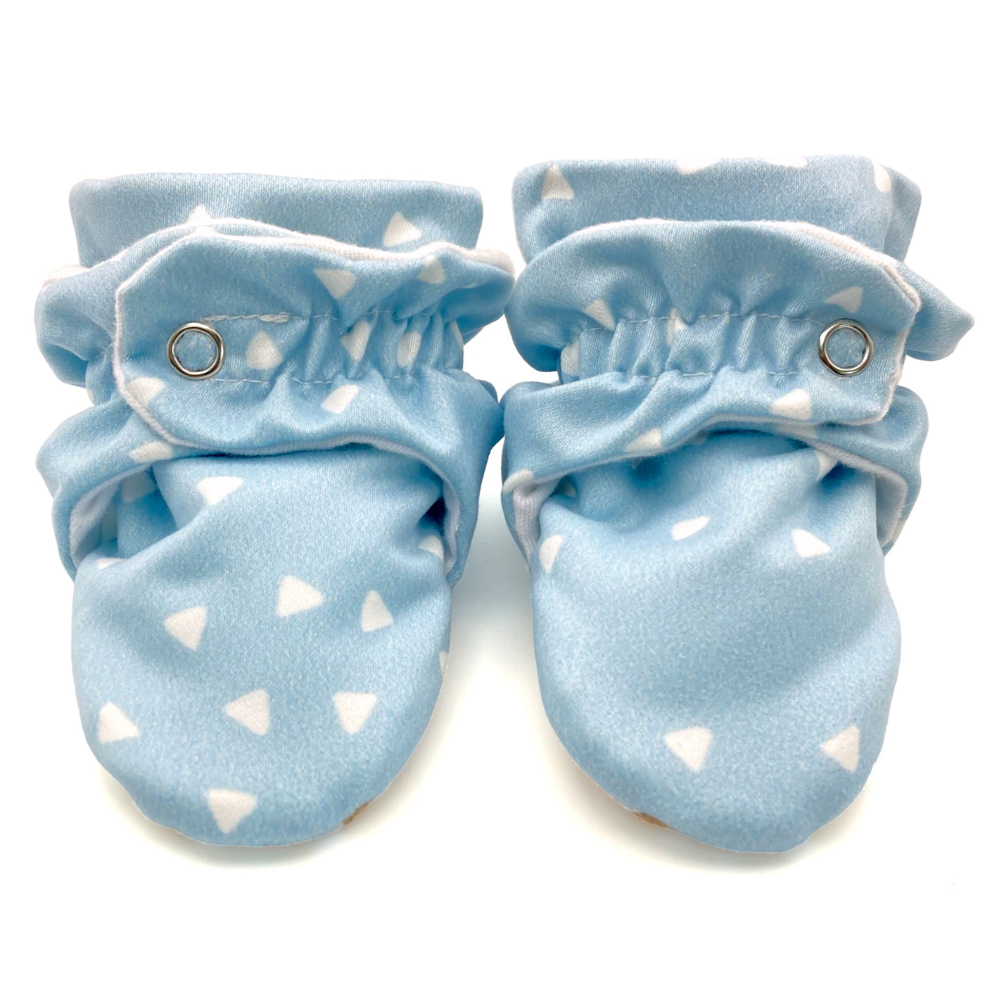 Stay-on baby booties featuring white triangles on a baby blue background print, with non-slip soles and adjustable three snap closure. Made from organic cotton. 